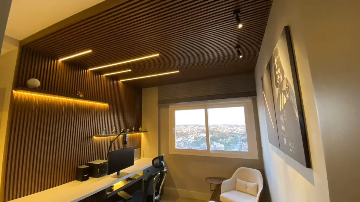 Home office planejado com forro ripado e bancada iluminada
