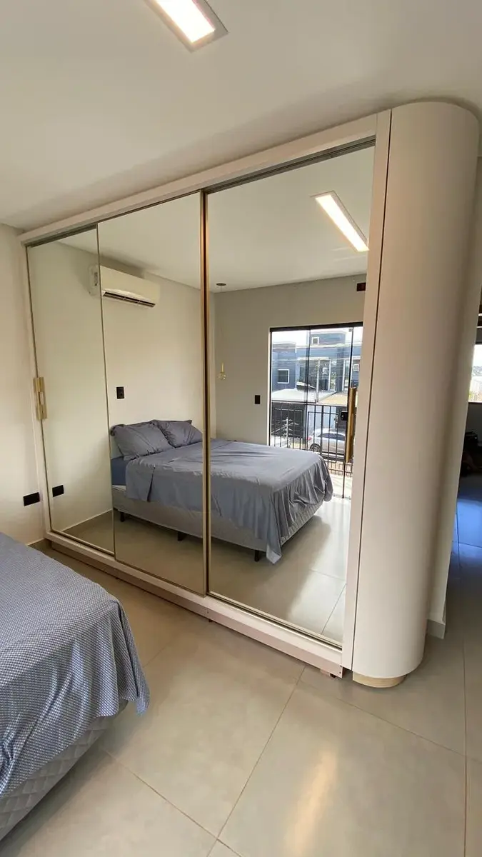 Guarda-roupa planejado com portas de espelho e canto arredondado
